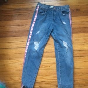 Ripped jeans with Side of a glitter strip.